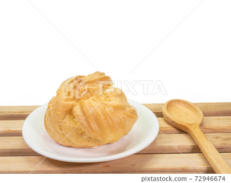 The close up of homemade vanilla custard choux cream (cream puff pastry), sweet bakery food with wooden plank on white background. 72946674