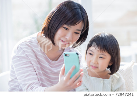 Family and mom watching a smartphone Family and mom watching a smartphone 72947241