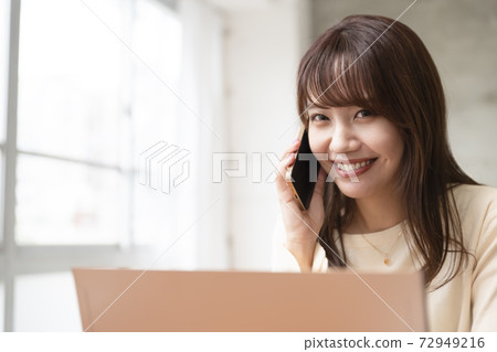 Woman business by the window making a phone call Woman business by the window making a phone call 72949216
