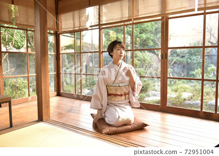 一個年輕漂亮的和服女子直立在日本房間的走廊裡 72951004