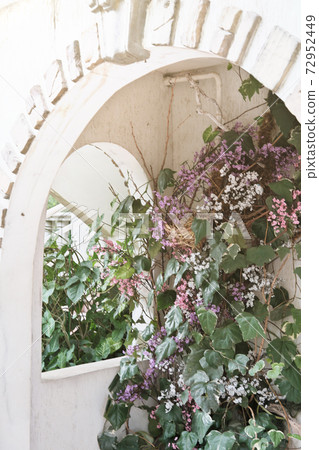 old house front with arch entwined with flowers. old house front with arch entwined with flowers. 72952449