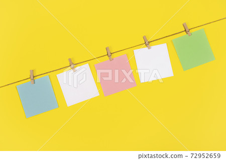 Note papers and decorative pin or clip isolated on yellow background. Office mock up. 72952659