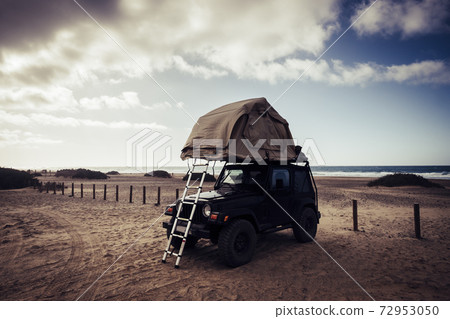 Off grid concept independence life with black off road car and tent on the roof to sleep and live alone in thw wild - travel lifestyle people with alternative vehicles transportation system Off grid concept independence life with black off road car and tent on the roof to sleep and live alone in thw wild - travel lifestyle people with alternative vehicles transportation system 72953050