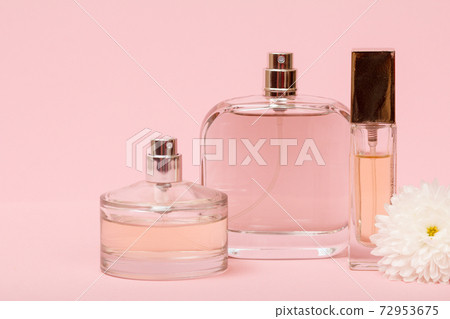Women perfumes with flower on the pink background. Women perfumes with flower on the pink background. 72953675