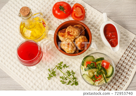 Fried meat cutlets in bowl, salad, glass of wine and bottle with sunflower oil Fried meat cutlets in bowl, salad, glass of wine and bottle with sunflower oil 72953740