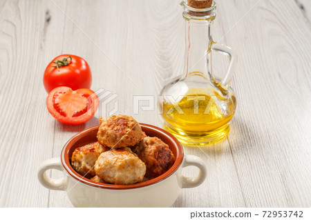 Fried meat cutlets in ceramic soup bowl with tomatoes and sunflower oil Fried meat cutlets in ceramic soup bowl with tomatoes and sunflower oil 72953742
