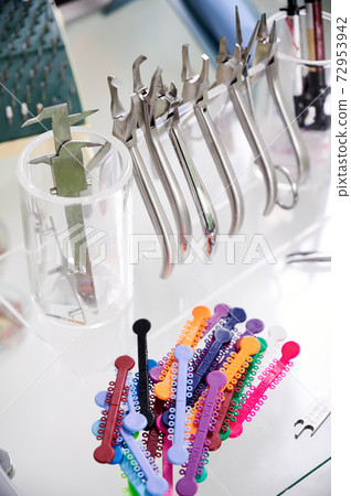 Glass table with dental instruments and orthodontic ligatures. 72953942