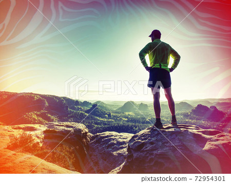 Silhouette of young sport man outdoors watching color sunset 72954301