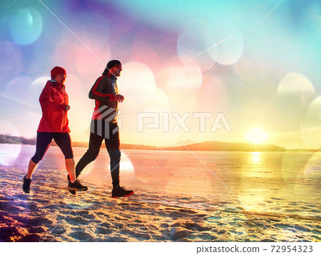 Couple Running along sea shore Couple Running along sea shore 72954323
