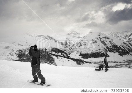 Group of snowboarders starts on off piste descent Group of snowboarders starts on off piste descent 72955708