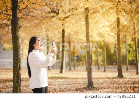 Asian beautiful woman is travel for holiday in the winter of Europe and view autumn leaves of big tree in Lausanne city at Switzerland,Vintage style and copy space. Asian beautiful woman is travel for holiday in the winter of Europe and view autumn leaves of big tree in Lausanne city at Switzerland,Vintage style and copy space. 72956211