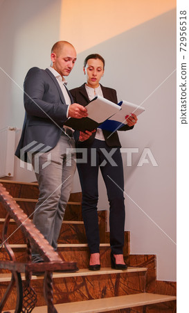 Office executive holding clipboard pointing on it Office executive holding clipboard pointing on it 72956518