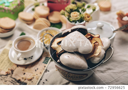 Christmas cookies, macarons, tea roses and coffee with milk. Food still life. Selective focus. Christmas cookies, macarons, tea roses and coffee with milk. Food still life. Selective focus. 72956625
