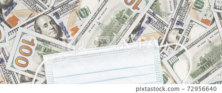 Protective face mask over hundred dollar bills. Coronavirus costs ppe business Protective face mask over hundred dollar bills. Coronavirus costs ppe business 72956640