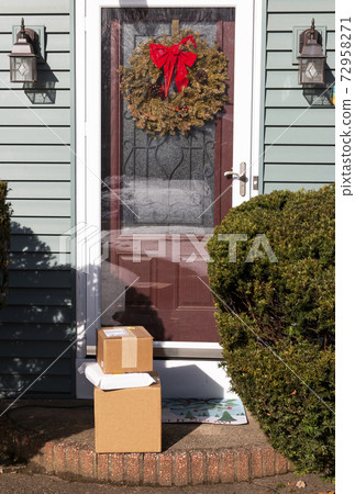Three packages delivered to front door with Christmas wreath in December Three packages delivered to front door with Christmas wreath in December 72958271