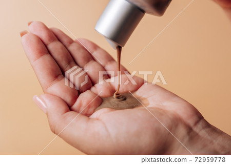 Girl pours chocolate shampoo into her hand 72959778