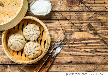 Asian steamed dumplings Manti in a bamboo steamer. Wooden background. Top view. Copy space 72961578
