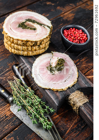 Sliced Italian pancetta on a cutting board. Dark Wooden background. Top view Sliced Italian pancetta on a cutting board. Dark Wooden background. Top view 72961692