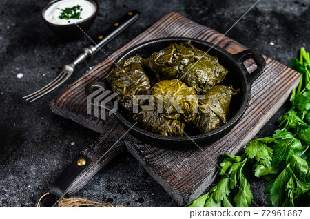 Dolma stuffed grape leaves with rice and meat. Black background. Top view 72961887
