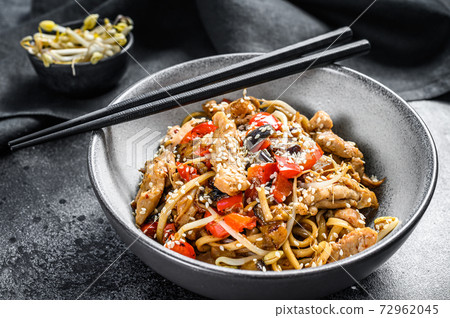 Udon stir-fry noodles with chicken meat and sesame. Black background. Top view 72962045