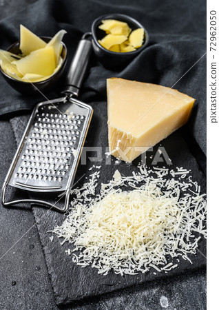 Italian hard Parmesan cheese slice, cut, grated. Black background. Top view Italian hard Parmesan cheese slice, cut, grated. Black background. Top view 72962050