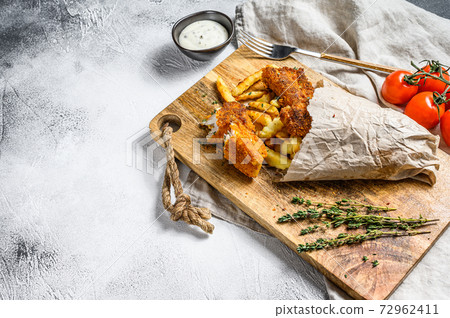 Fish and chips, French fries and cod fillet fried in breadcrumbs. Gray background. Top view. Copy space 72962411
