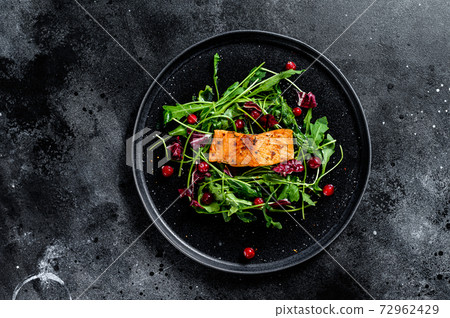 Seafood salad with salmon, arugula, lettuce and cranberries. Black background. Top view. Copy space 72962429