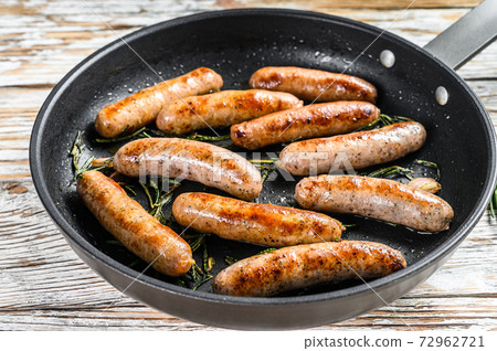 Homemade sausages fried in a pan, beef and pork meat. wooden background. Top view 72962721