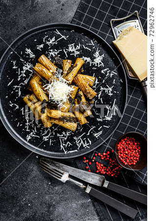 Pasta tortiglioni with black truffle, white mushroom, Cream Sauce and parmesan cheese. Black background. Top view 72962746