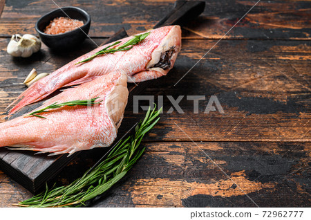 Whole raw fresh red perch or seabass fish. Dark wooden background. Top view. Copy space Whole raw fresh red perch or seabass fish. Dark wooden background. Top view. Copy space 72962777