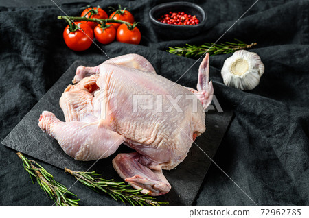 Concept of cooking whole chicken with rosemary and pink pepper. Black background. Top view 72962785