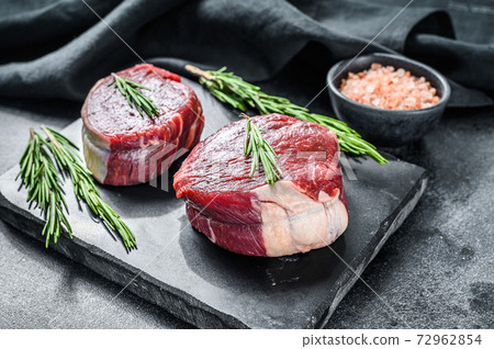 Raw steak Tenderloin fillet on a stone board. Black background. Top view 72962854