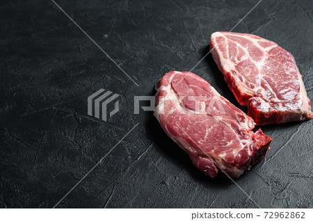Raw pork steak on the bone. Grilled meat. Black background. Top view. Space for text Raw pork steak on the bone. Grilled meat. Black background. Top view. Space for text 72962862