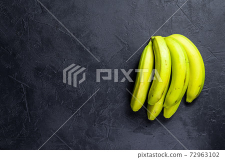 Green bananas. Black background. Top view. Space for text Green bananas. Black background. Top view. Space for text 72963102