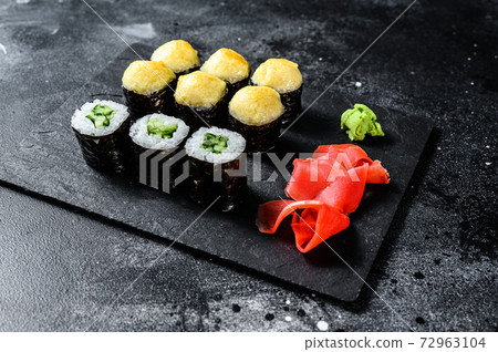 Various kinds of sushi served on black stone. Black background. Top view 72963104