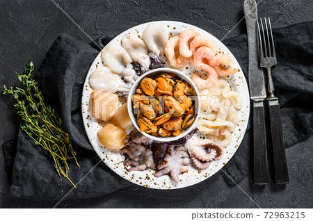 Boiled seafood mix, sea cocktail. Black background. Top view. Space for text 72963215