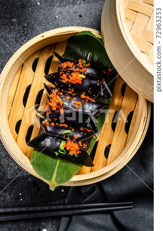 Steamed dumplings Dim Sum in bamboo steamer. Black background. Top view Steamed dumplings Dim Sum in bamboo steamer. Black background. Top view 72963253