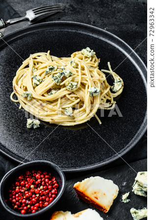 Spaghetti paste with cream blue cheese sauce and walnuts. Italian Home made food. Concept for a tasty, vegetarian dish. Black background. Top view Spaghetti paste with cream blue cheese sauce and walnuts. Italian Home made food. Concept for a tasty, vegetarian dish. Black background. Top view 72963342