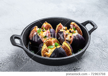 Baked figs with cream cheese, honey and nuts. White background. Top view 72963708