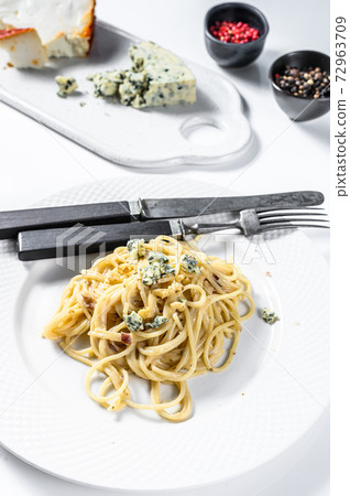 Spaghetti paste with cream blue cheese sauce and walnuts. Italian Home made food. Concept for a tasty, vegetarian dish. White background. Top view 72963709