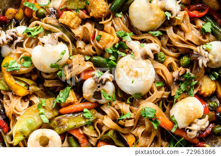 Wok with stir fry Udon noodles, seafood and vegetables. White background. Top view Wok with stir fry Udon noodles, seafood and vegetables. White background. Top view 72963866