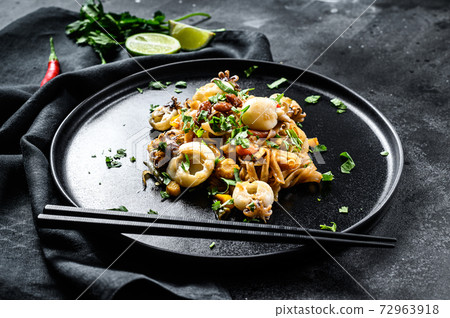 Asian stir fry Noodles with cuttlefish and vegetables. Black background. Top view 72963918