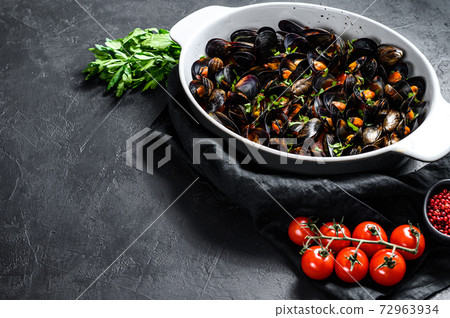Mussels in tomato sauce with parsley and herbs. Black background. Top view. Space for text Mussels in tomato sauce with parsley and herbs. Black background. Top view. Space for text 72963934