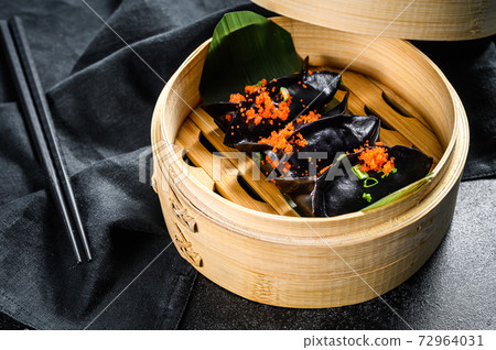 Black Dim sum dumplings in bamboo steamer. Asian cuisine. Black background. Top view Black Dim sum dumplings in bamboo steamer. Asian cuisine. Black background. Top view 72964031