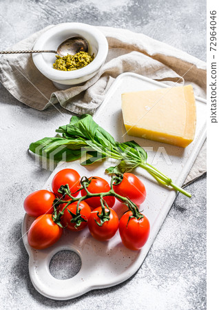 Homemade Pesto in marble mortar, Basil leaves and Parmesan on a chopping Board. Space for text 72964046