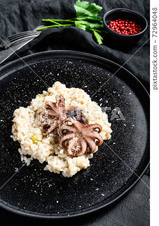 Italian homemade Risotto with octopus and mushrooms, parsley and spices. Black background. Top view 72964048
