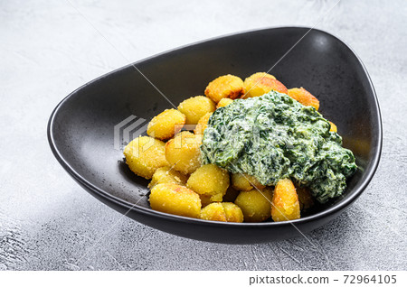 Fried gnocchi potato pasta with spinach. White background. Top view Fried gnocchi potato pasta with spinach. White background. Top view 72964105