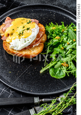 Breakfast Burger with bacon, egg Benedict, hollandaise sauce on brioche bun. Black background. Top view Breakfast Burger with bacon, egg Benedict, hollandaise sauce on brioche bun. Black background. Top view 72964363