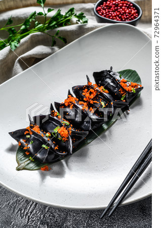 Black Dim sum dumplings. Asian cuisine. Gray background. Top view Black Dim sum dumplings. Asian cuisine. Gray background. Top view 72964371