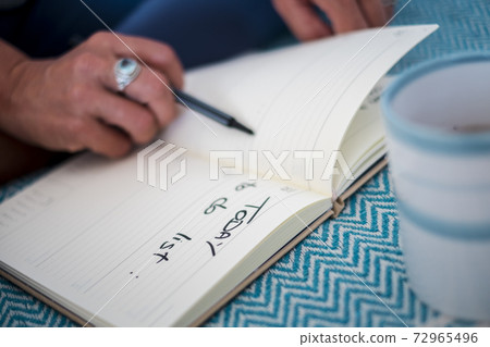 New change life project concept with lose up of woman writing the to do list on a notebook paper - white page ready to start - focus on blocks 72965496